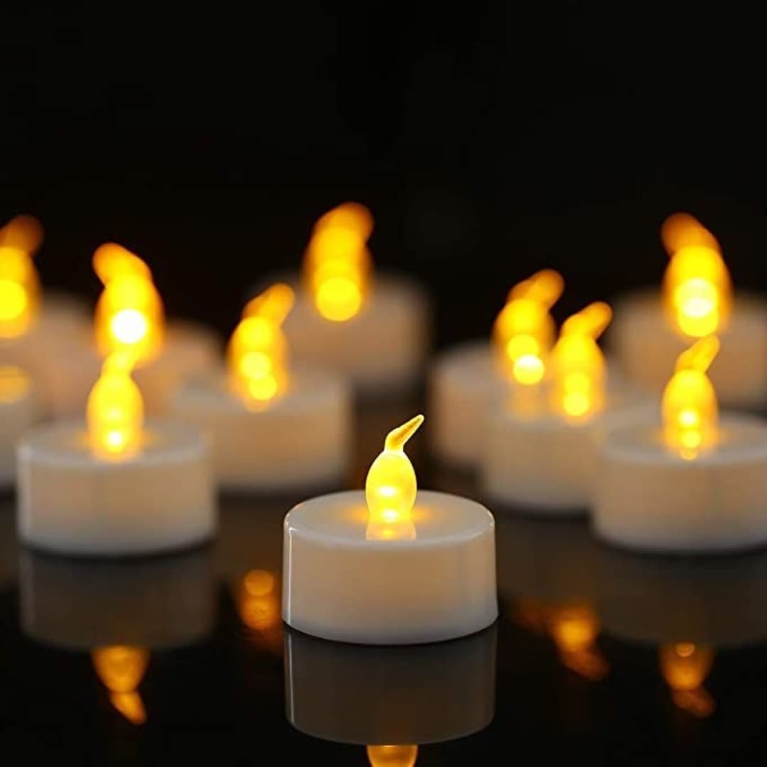 Detalle de vela LED decorativa con luz cálida y botón de encendido/apagado en la base