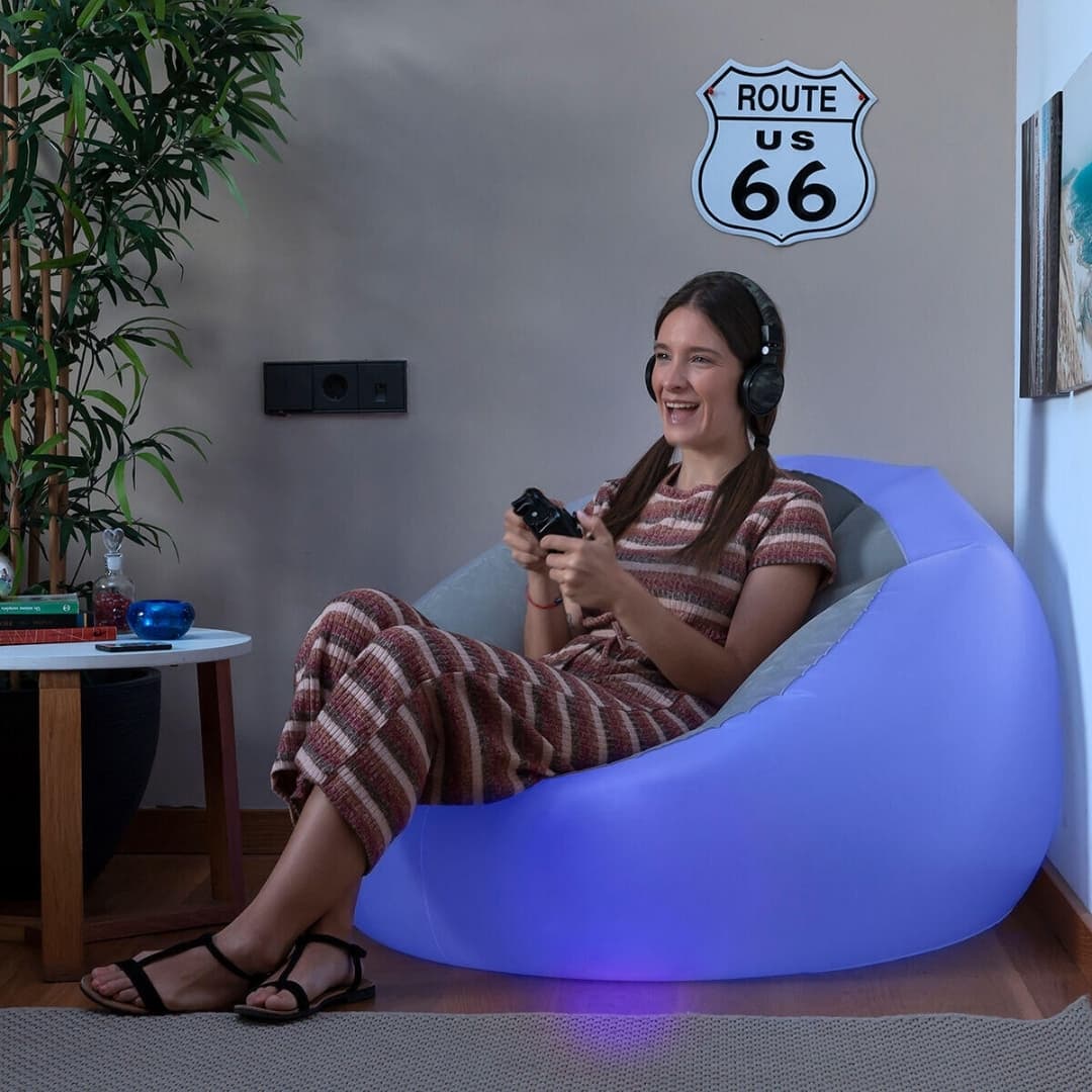 Sillón hinchable LED multicolor en camping nocturno creando ambiente acogedor