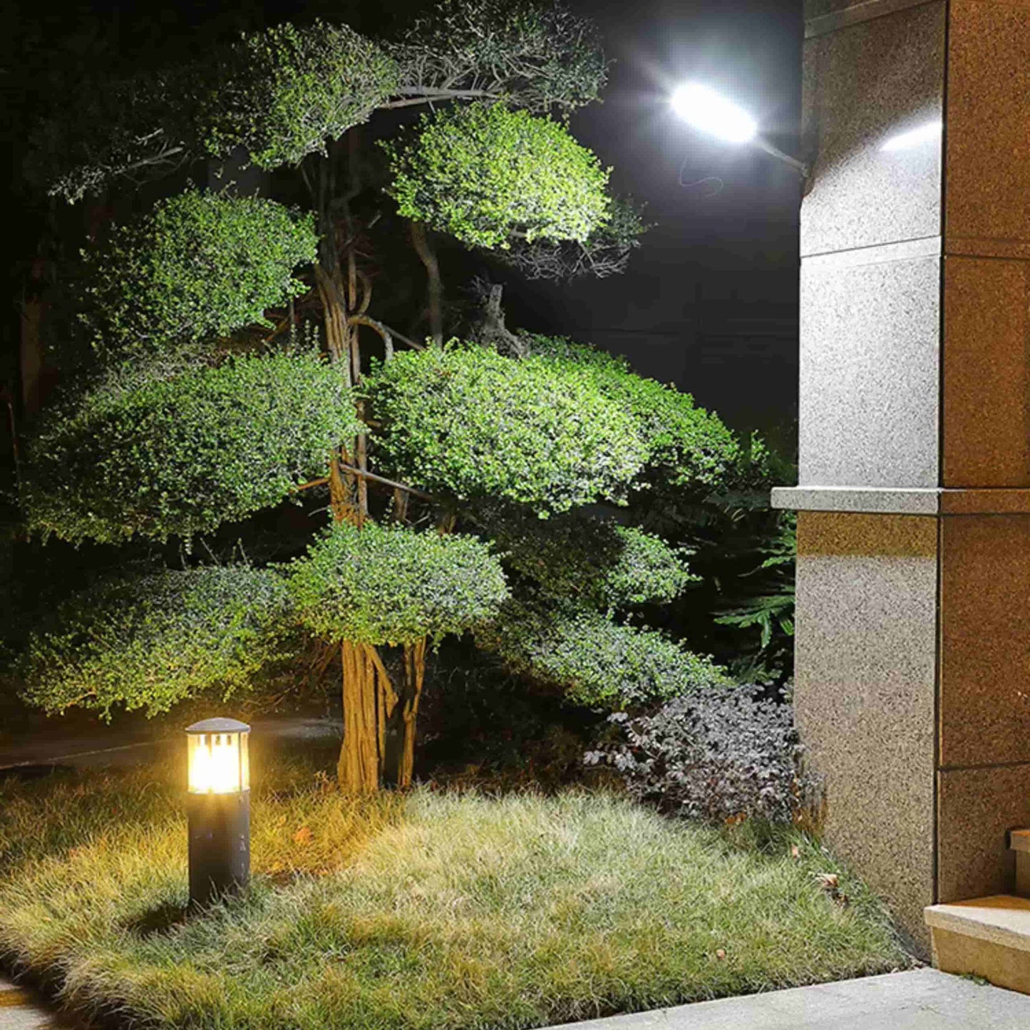 Farola solar LED instalada en la entrada de un edificio, activada por sensor de movimiento, ofreciendo seguridad e iluminación eficiente sin necesidad de electricidad.