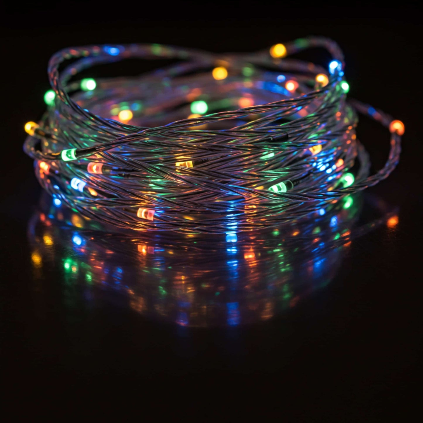 Guirnalda LED multicolor encendida en la oscuridad, con efecto de luz vibrante reflejada.