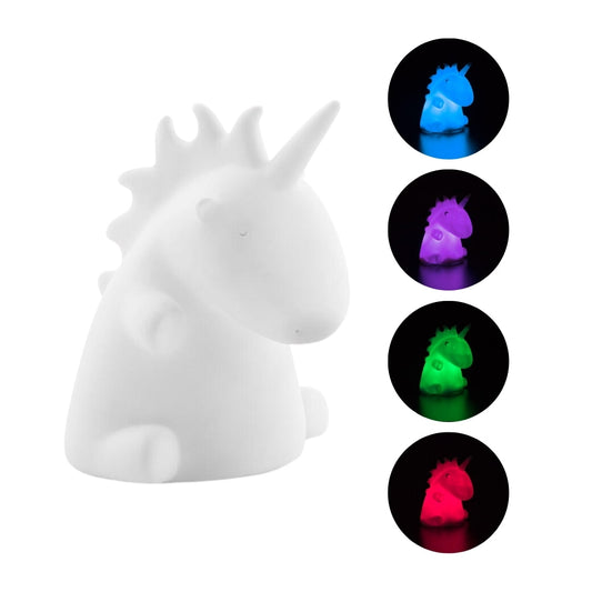 Lámpara unicornio LED multicolor encendida sobre mesilla infantil
