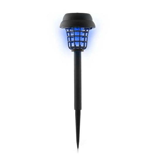 Lámpara solar antimosquitos negra instalada en jardín con luz LED encendida