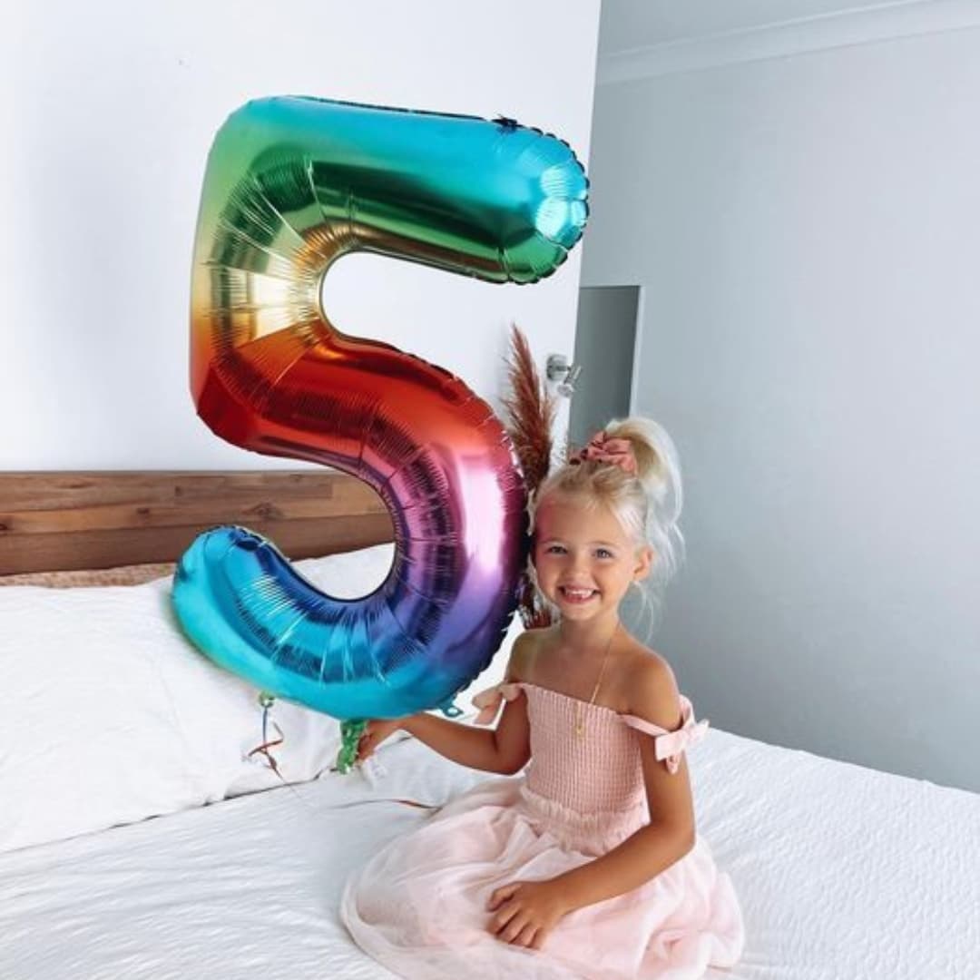 Globo metálico número 5 en sesión de fotos, fondo brillante y festivo