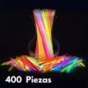 Pulseras luminosas Glow Elite iluminadas sobre mesa con jarra Pulseras luminosas Glow Elite encendidas sobre una mesa junto a una jarra en ambiente nocturno