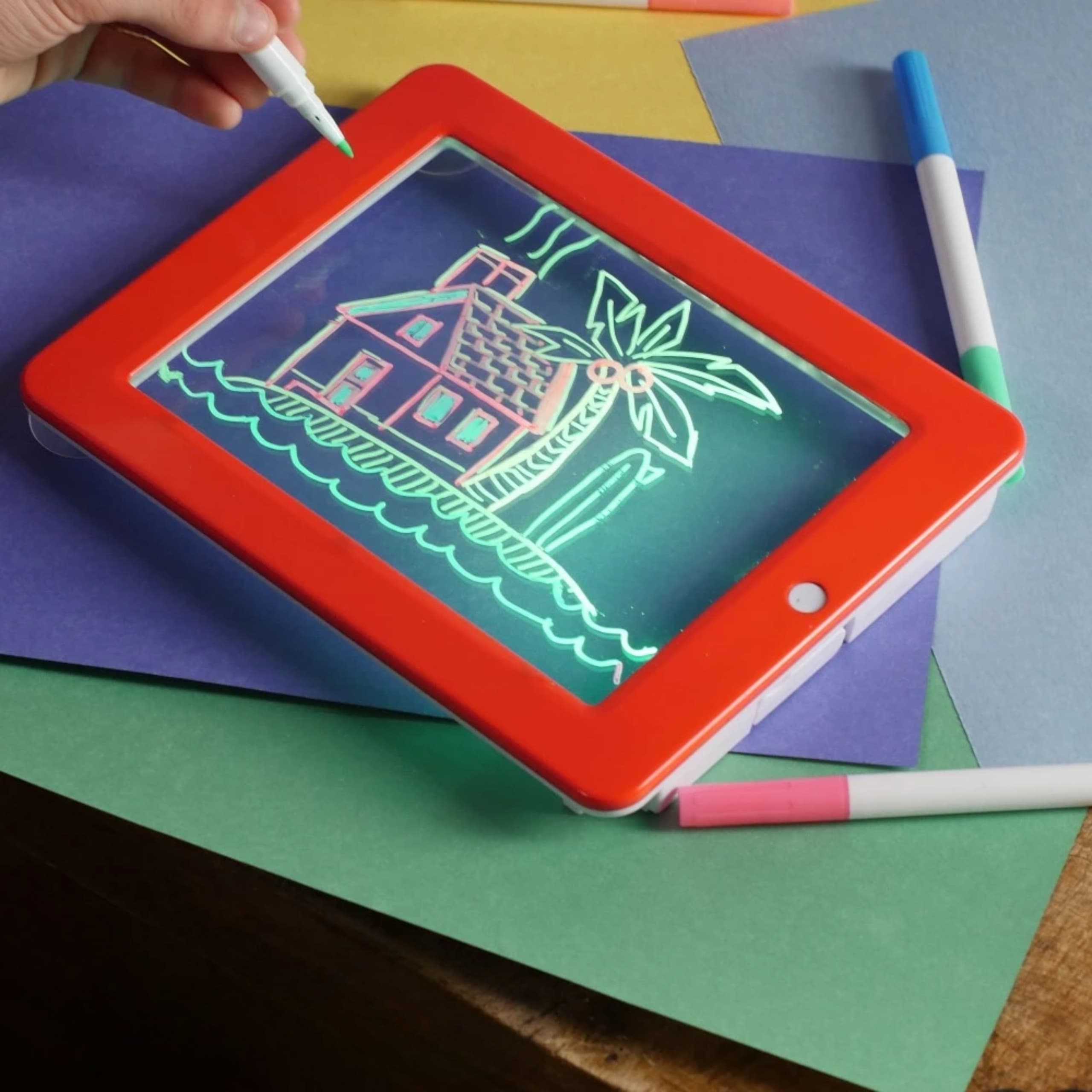 Tableta MagicPad mostrando un dibujo terminado iluminado con luces neón de colores brillantes