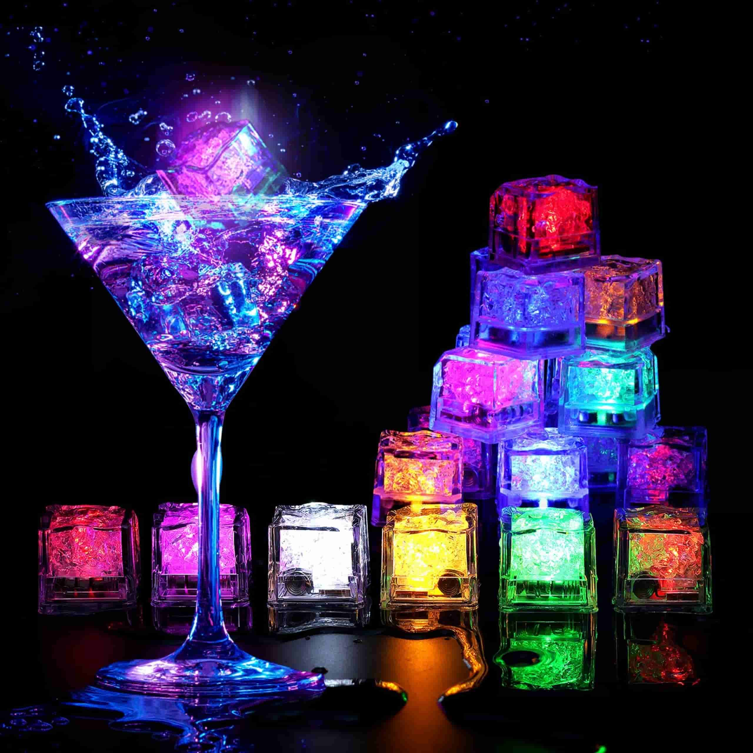 Cubitos de Hielo LED iluminando vasos de agua sobre mesa Cubitos de hielo LED encendidos dentro de vasos de agua sobre una mesa, mostrando colores brillantes en la oscuridad