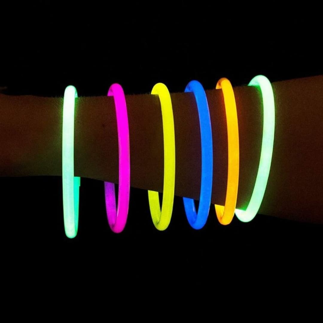 Mano con pulseras luminosas Glow Elite multicolor Mano con pulseras luminosas Glow Elite encendidas mostrando colores brillantes en ambiente nocturno