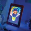 Tableta MagicPad encendida con un dibujo colorido en luces neón brillantes