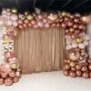 Globos oro rosa y dorado decorando una fiesta interior con luces y ambiente festivo