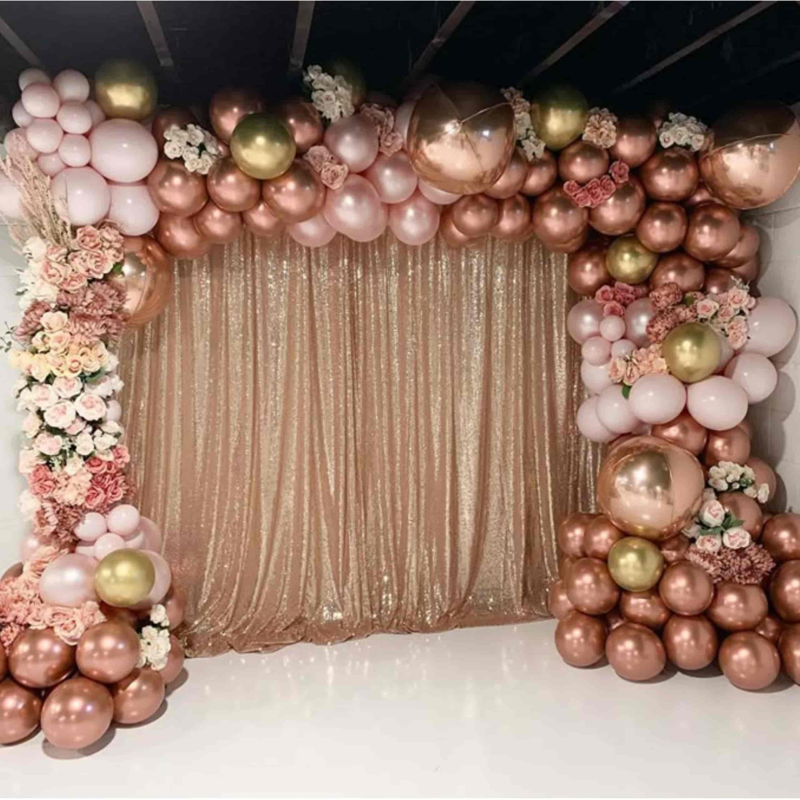 Globos oro rosa y dorado decorando una fiesta interior con luces y ambiente festivo