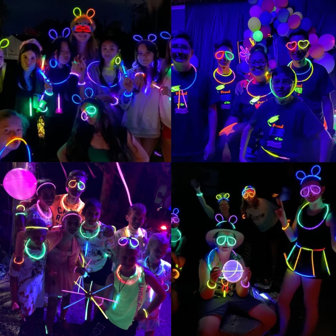 Grupo de amigos usando pulseras luminosas Opti Glow multicolor en una fiesta nocturna y disfrutando juntos