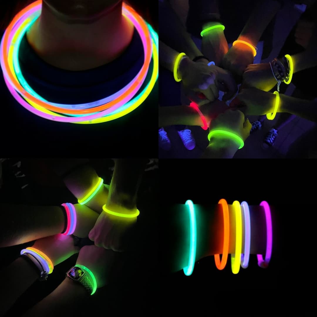 Pulseras fluorescentes Lumi Flex usadas en manos y cuellos Manos y cuellos adornados con pulseras fluorescentes Lumi Flex multicolor durante una fiesta nocturna
