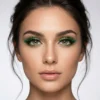 Look Profesional con Pestañas de Colores Primer plano de modelo con maquillaje de ojos resaltado por pestañas postizas verdes de varias capas y volumen extremo.