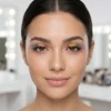 Primer plano de una mujer luciendo pestañas postizas arcoíris para un look de maquillaje de fantasía y festivales.