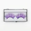Pestañas Postizas Violetas con Brillo – Vista Frontal Pestañas postizas moradas de fantasía con glitter en estuche transparente sobre fondo blanco profesional.