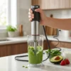 Batidora de mano para smoothies y batidos Batidora de mano potente preparando un smoothie verde con aguacate y espinacas en un vaso medidor.