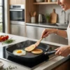 Mujer cocinando tortitas y huevos en sartén asador cuadrada lisa sobre placa de inducción, demostrando su versatilidad.