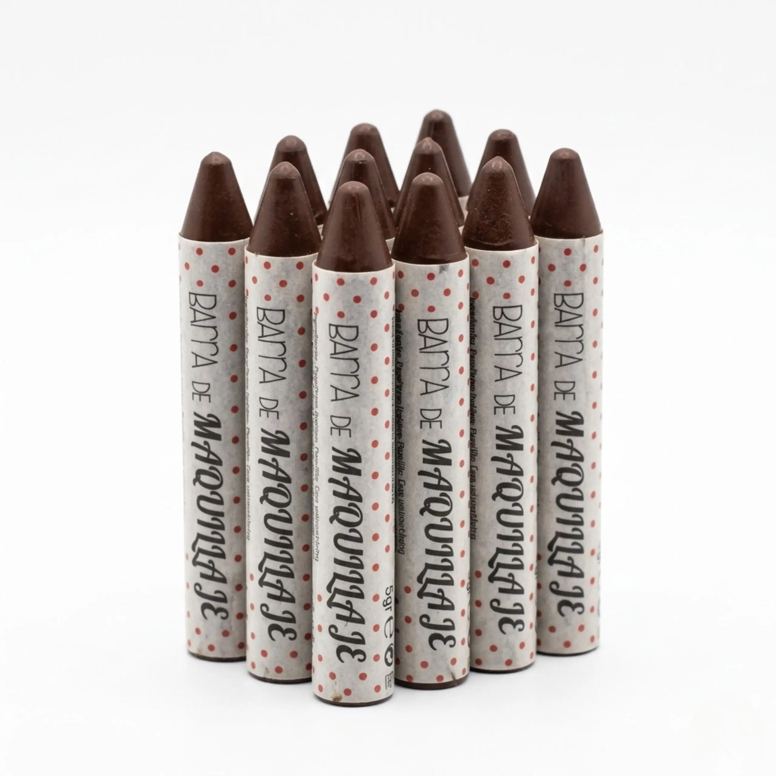 Set de 12 barras de maquillaje multiusos color marrón con punta cónica para labios y ojos sobre fondo blanco.