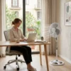Ideal para Oficina y Trabajo Mujer trabajando con laptop en escritorio refrescada por un ventilador de pie DVTECH, ideal para mantener la concentración.