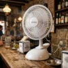 Ventilador Portátil de Base Estable para Negocios Ventilador DVtec con base circular colocado sobre una barra de bar de madera, demostrando su estabilidad y diseño compacto para hostelería.