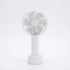 Uso del ventilador portátil en exteriores Grupo de jóvenes usando el ventilador de mano portátil recargable en una calle turística para refrescarse durante el verano.
